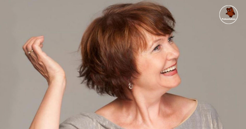 A woman with short hair smiles, showcasing one of the 30 fabulous short hairstyles for women over 70 to inspire your next cut.