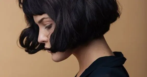 A woman with a stylish short black bob haircut, showcasing a chic and modern look in her Short Auburn Bob Makeover.